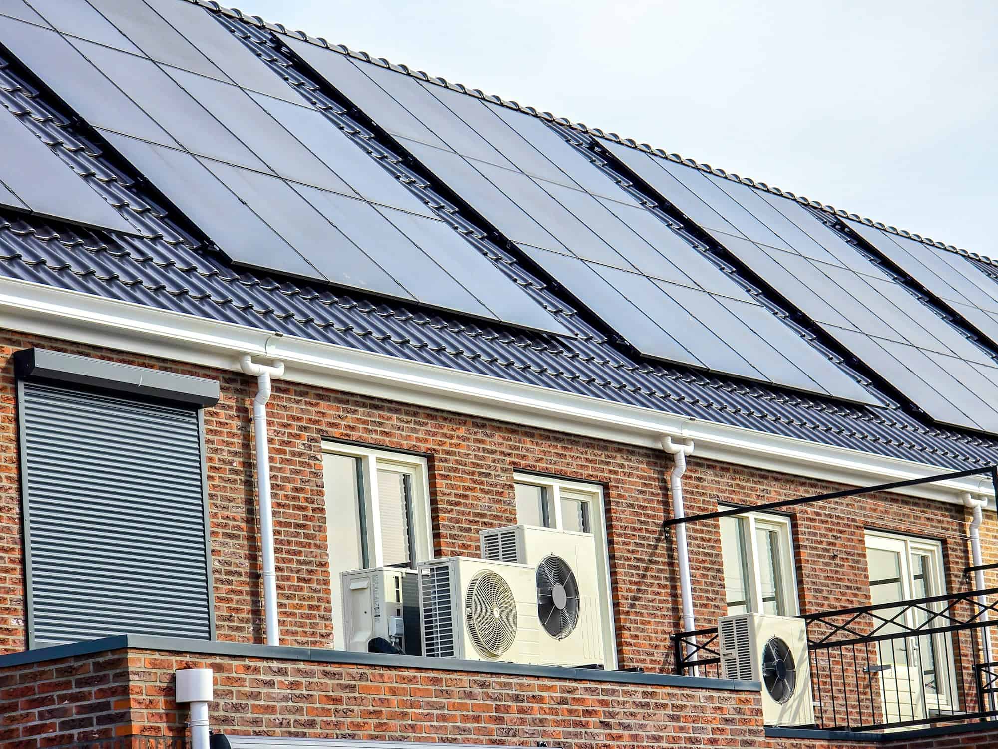 air source heat pump unit installed outdoors at a modern home with solar panels in the Netherlands