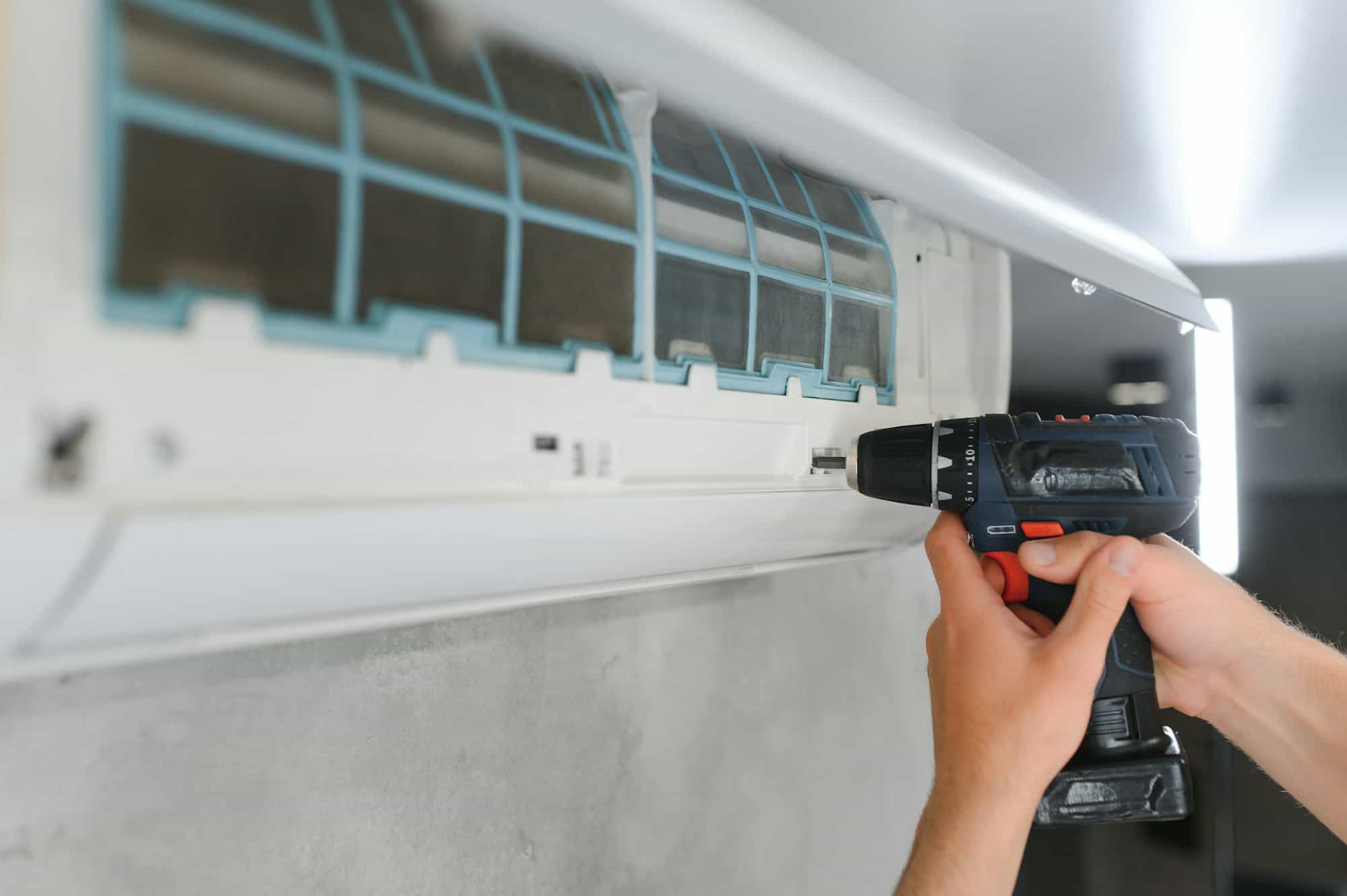 specialist cleans and repairs the wall air conditioner